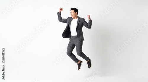 Enthusiastic businessman jumping for joy on white background