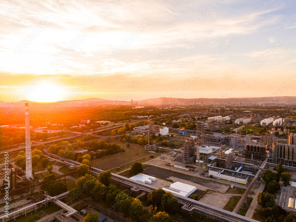 Fototapeta premium Sunset view over industrial area with skyline and sky in the background