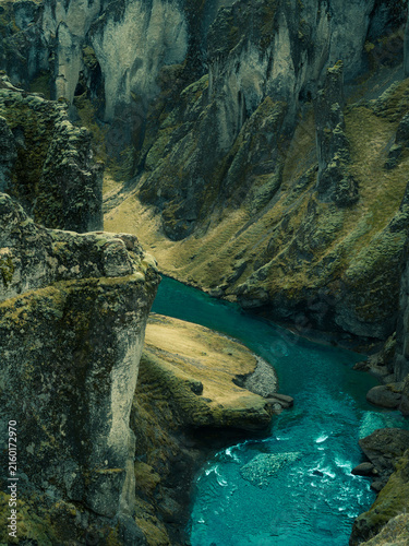 Winding river through dramatic moss-covered canyon in Iceland