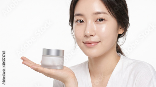 Asian woman holding skincare cream jar on white background