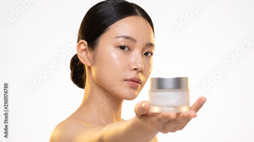 Beautiful asian woman holding cosmetic cream jar for skincare