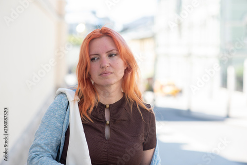  Sad and tired 40 years old woman with red hair outdoors