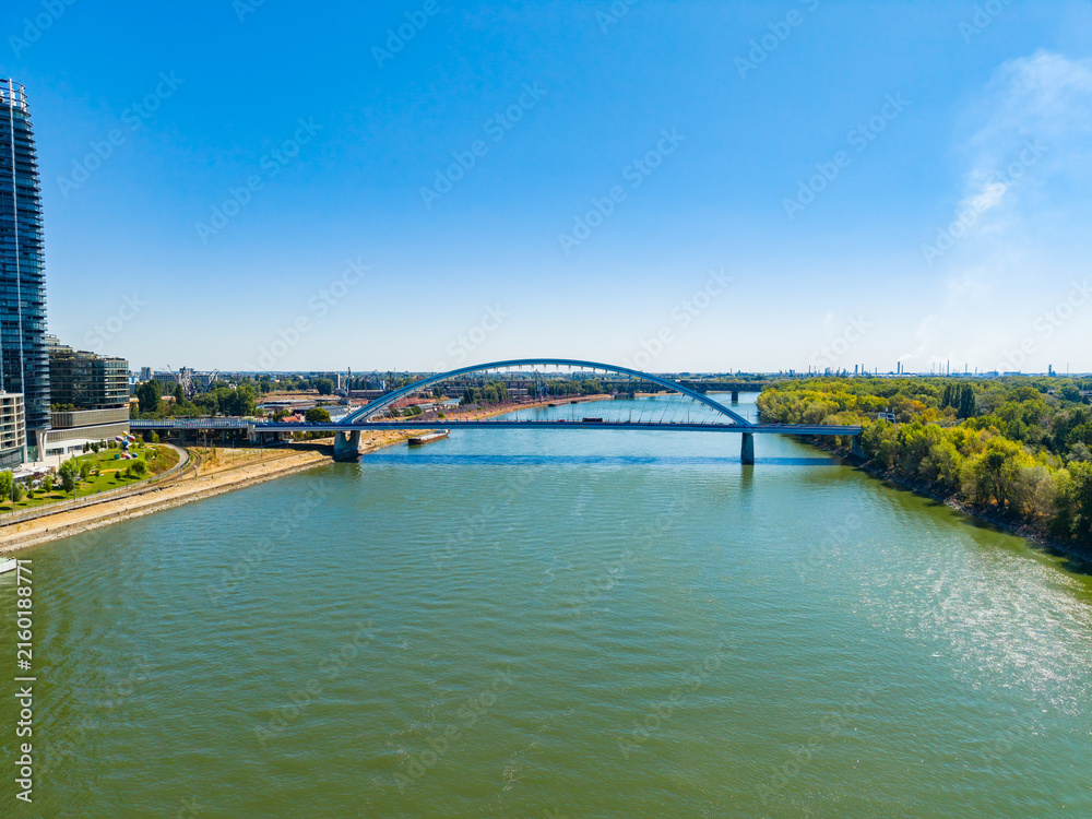Fototapeta premium View of a river with a bridge and buildings during a clear day in an urban area