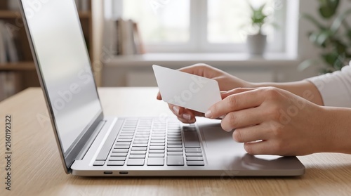 Hands holding credit card for online shopping on laptop computer