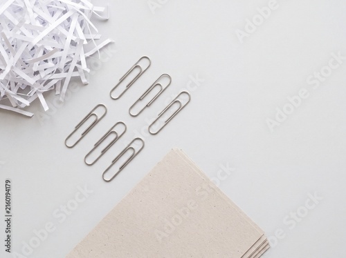 Recycled paper and paperclips arranged as a flat lay
