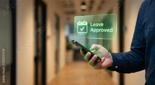 Employee hand holding smartphone with holographic time-off leave request approval interface, digital HR self-service concept in office hallway
