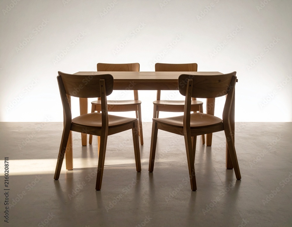 Fototapeta premium Minimalist wooden table with an additional prepared chair bathed in morning light for inclusion and equal opportunity concepts