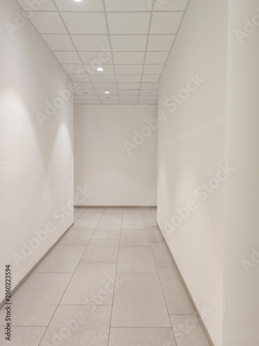 Фотография Empty, brightly lit hallway that terminates at a blank white wall