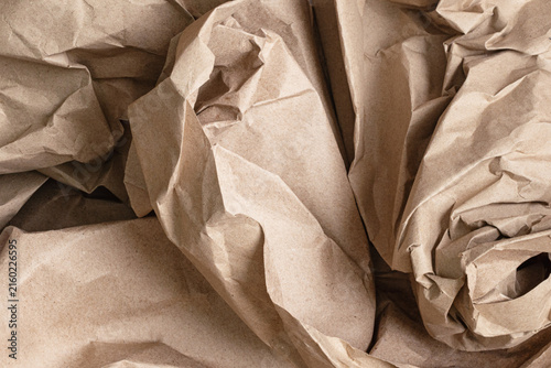 Crumpled kraft paper texture with natural brown tones, wrinkles and folds, creating a rustic organic background for packaging, crafts and design.