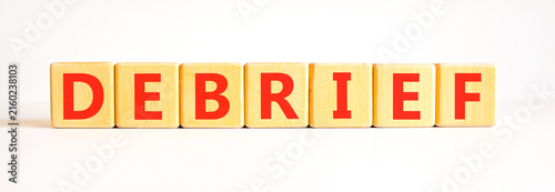 Debrief word symbol. Concept word Debrief on beautiful wooden blocks. Beautiful white table white background. Business debrief word concept. Copy space.