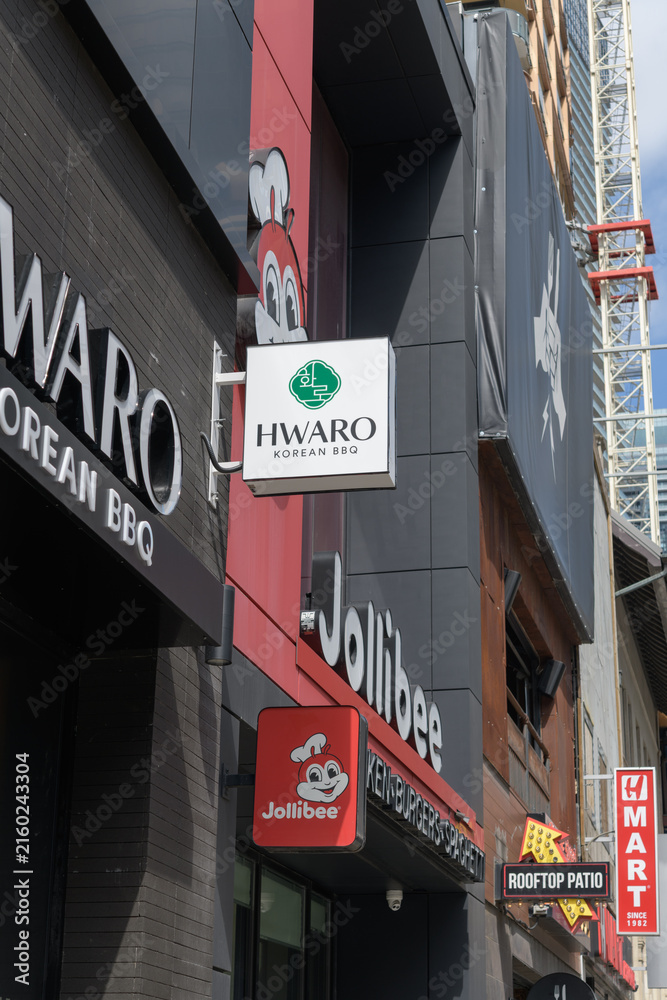 Naklejka premium Hwaro Korean BBQ (332 Yonge St) and Jollibee chicken restaurant (334 Yonge St) signs in Toronto