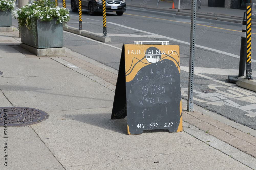 Naklejka premium a-frame chalkboard sign outside Paul Hahn & Co, a piano store, located at 1058 Yonge St, Toronto