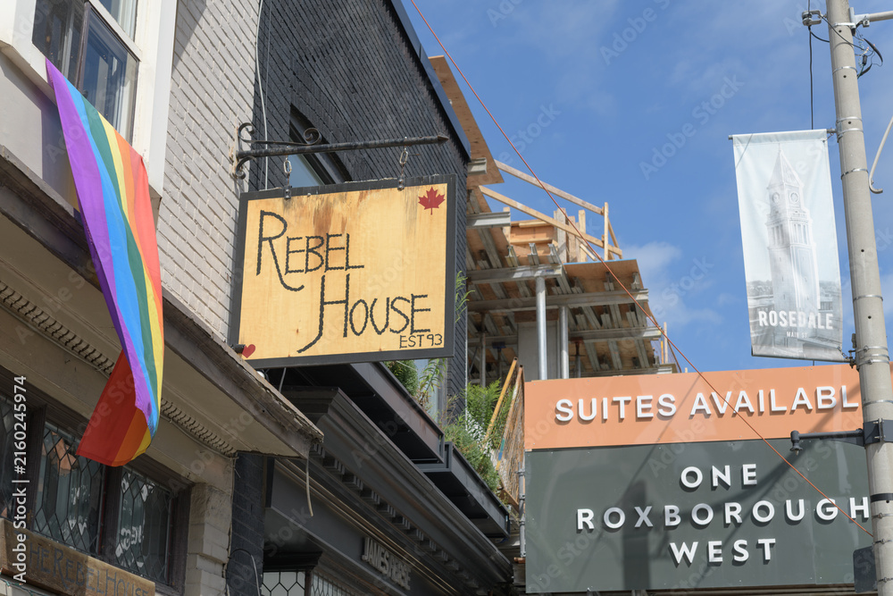 Fototapeta premium projecting sign outside The Rebel House and construction site signage at One Roxborough West, Toronto