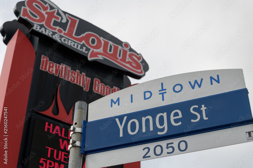 Fototapeta premium road sign at 2050 Yonge St in Midtown Toronto (defocused view of St. Louis Bar & Grill)