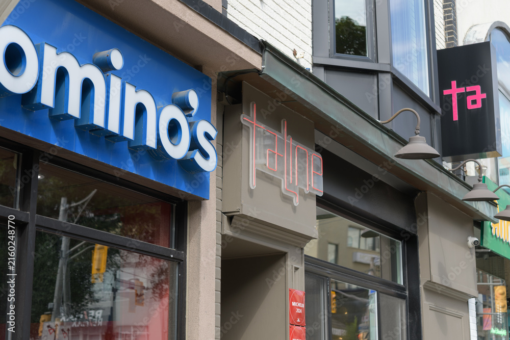 Fototapeta premium building facades and signs of Domino's Pizza (1272 Yonge St) and Taline, an Armenian restaurant (1276 Yonge St), in Toronto