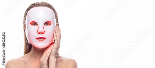 A woman in LED light facial mask. Cosmetology concept, and beauty device, woman advertising of antiaging beauty skin care products, isolated