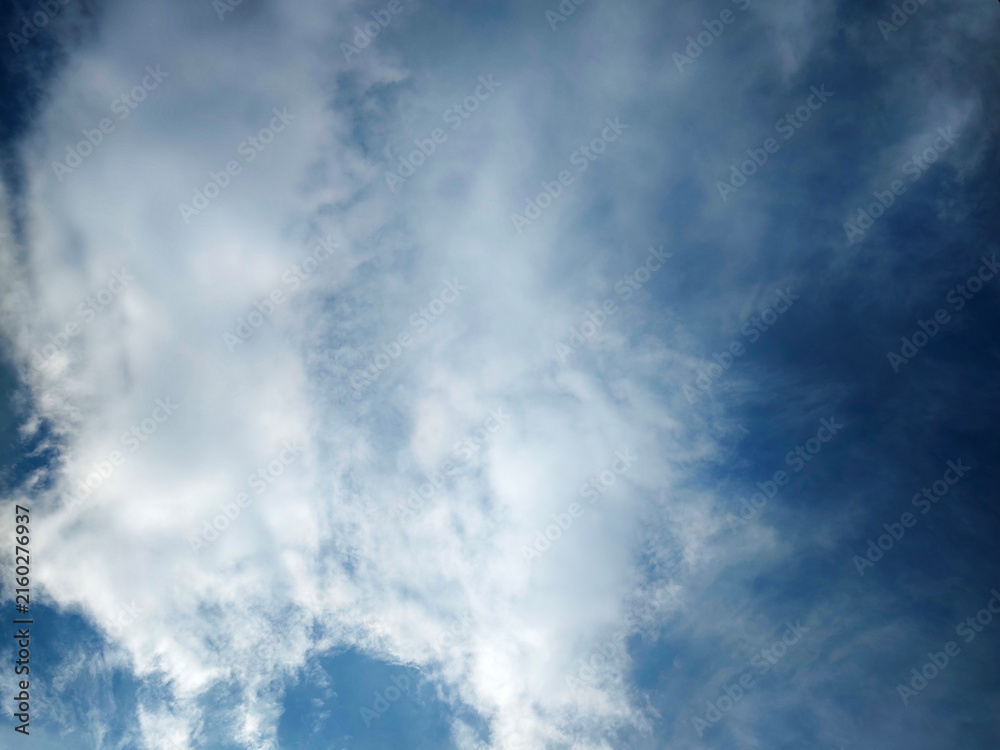 Obraz premium Calm blue sky filled with soft white clouds, perfect for backgrounds