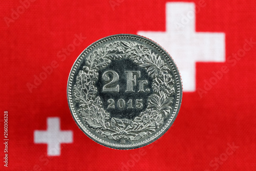 This single coin, worth two francs, is shown against a backdrop of Swiss flag symbols
