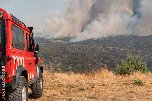 Viatura de combate a incêndios posicionada num alto em Vilarinho da Castanheira a monitorizar uma densa coluna de fumo que cobre a vegetação das serras fustigadas pelo fogo em Portugal