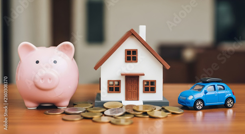 Personal Financial Planning Concept with Piggy Bank House Model and Toy Car for Real Estate and Vehicle Investment Savings