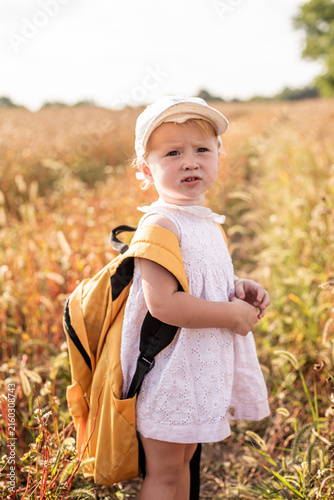 Konstfotografi Child in field with school backpack