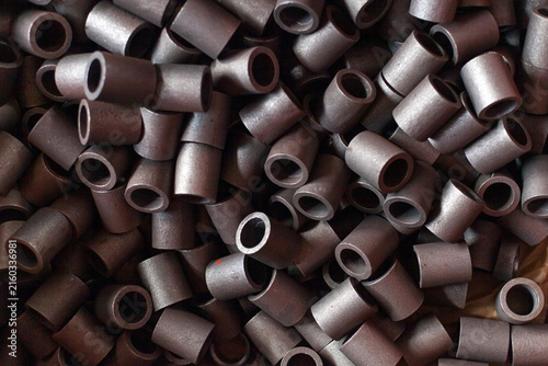 Foto Pile of small industrial metal bushings or sleeves in tractor factory workshop