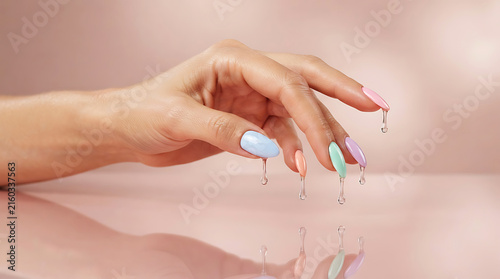 Hand holding pastel rainbow manicured nails, close-up