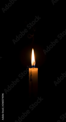 Burning candle with warm flame glowing in dark background religion peace, darkness