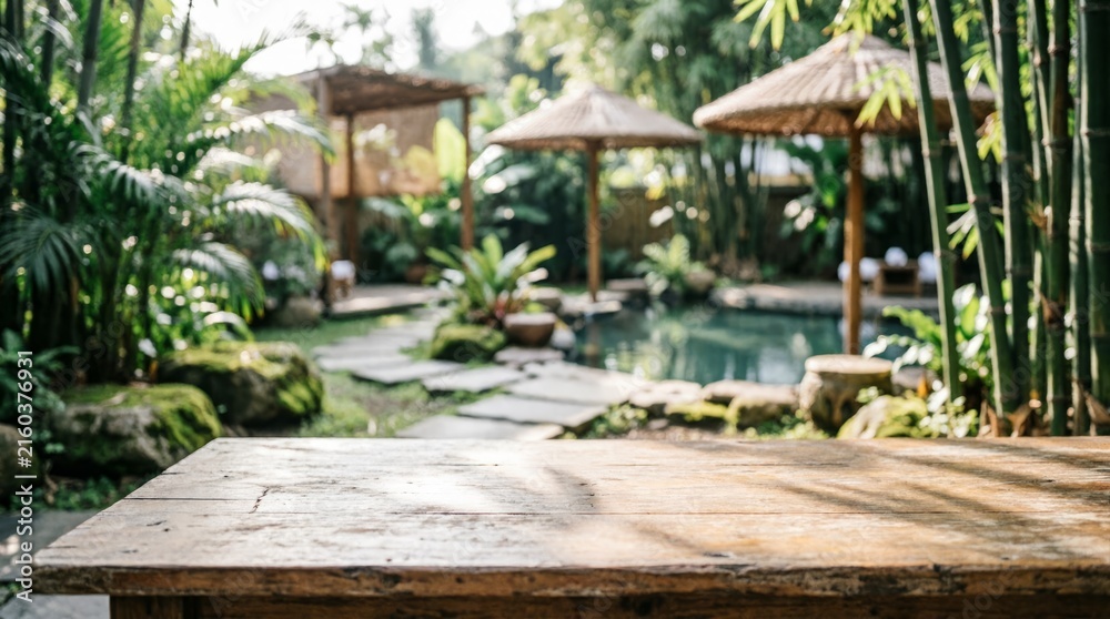 Fototapeta premium Wooden Table in Tropical Garden with Bamboo and Pool for Web Design