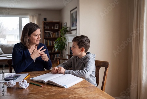 Adult Uses Sign Language While Helping Child With Math Homework