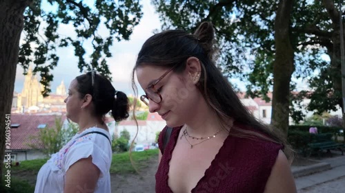 Women walking in a park with Santiago de Compostela cathedral in the background