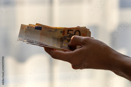 Hand holding fifty euro banknotes concept of wealth and savings