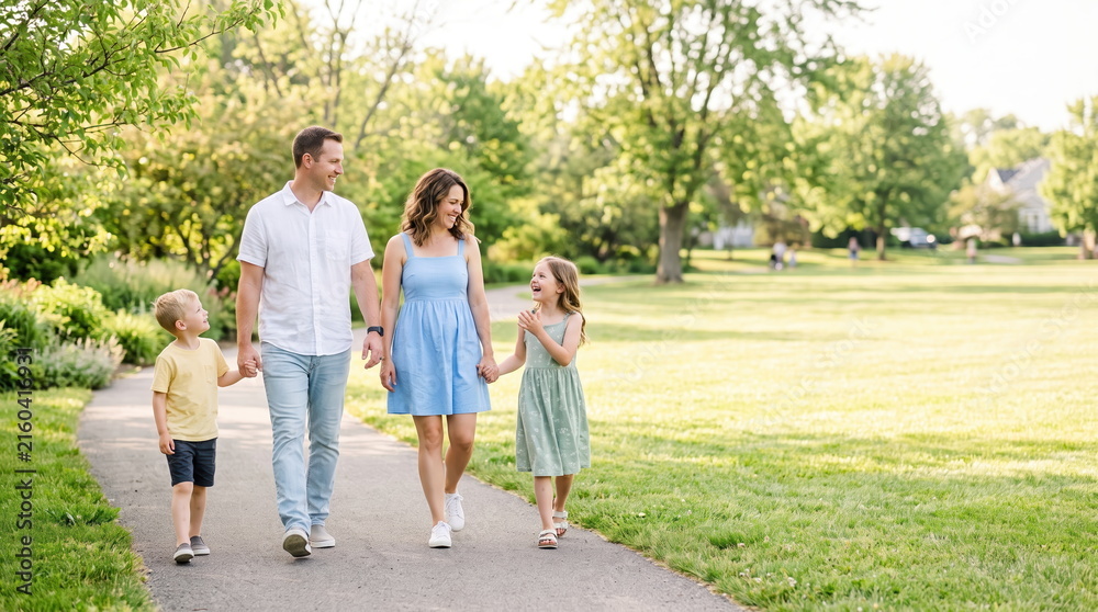Fototapeta premium Family walking together in a park enjoying quality time outdoors