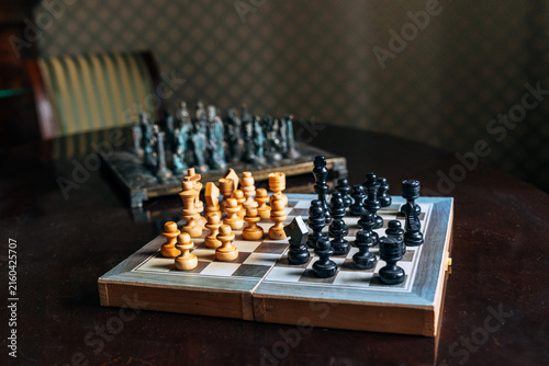 Vintage chess set with antique pieces on wooden table
