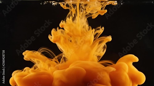 Vibrant yellow orange cloud of liquid forms; dynamic motion captured in dark water; suggests tropical elements and vivid energy