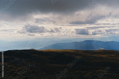 Foto A dramatic landscape of dark shadowed mountain plateaus under a heavy overcast s