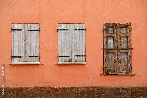 Vintage wooden window on a weathered plaster wall of an historic house