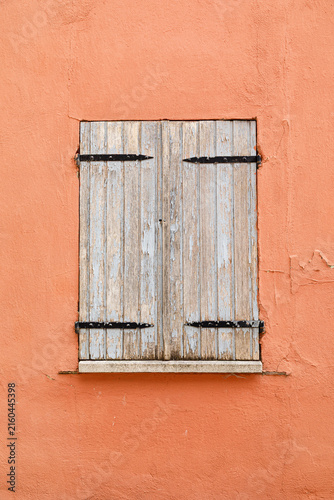Vintage wooden window on a weathered plaster wall of an historic house