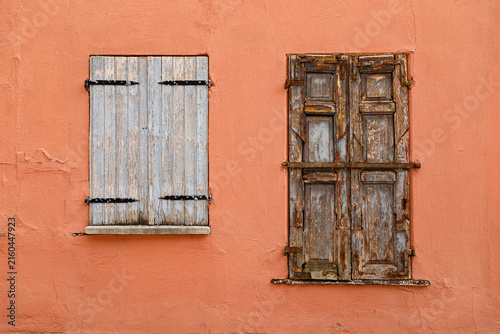 Vintage wooden window on a weathered plaster wall of an historic house