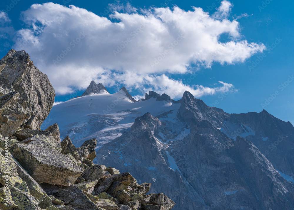 Obraz premium Alpine glacier and rugged mountain peaks under dramatic clouds in the French Alps, Chamonix, France