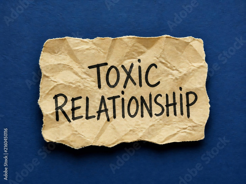Toxic relationship text on crumpled paper. Emotional abuse concept on torn craft note.