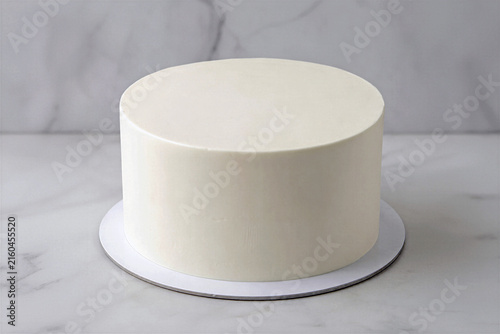 Blank round white buttercream cake mockup on silver cake board over marble background. Minimalist frosted cake template for bakery branding, custom design, text and digital decoration.