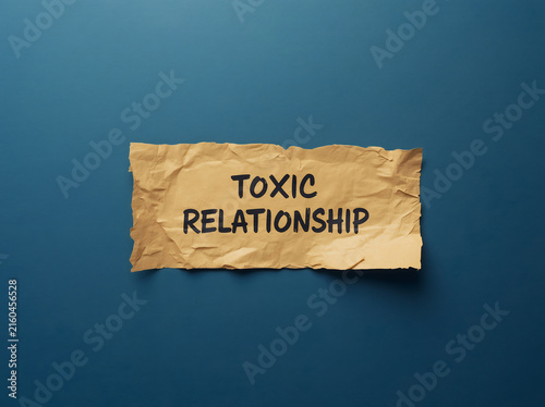 Toxic relationship warning label on crumpled paper. Emotional abuse concept with distressed handwritten note on torn background.