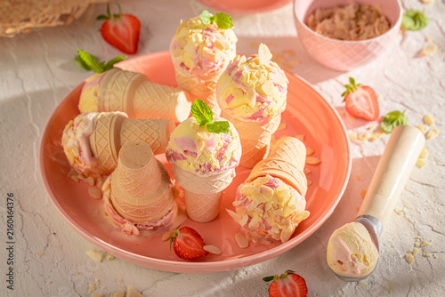 Cold and homemade strawberry ice cream with fruit and cream.