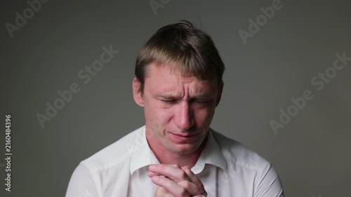 Businessman in a white t-shirt  with a sad and disappointed facial expression. Studio portrait isolated on a white background, suitable for business, stress andal concepts.