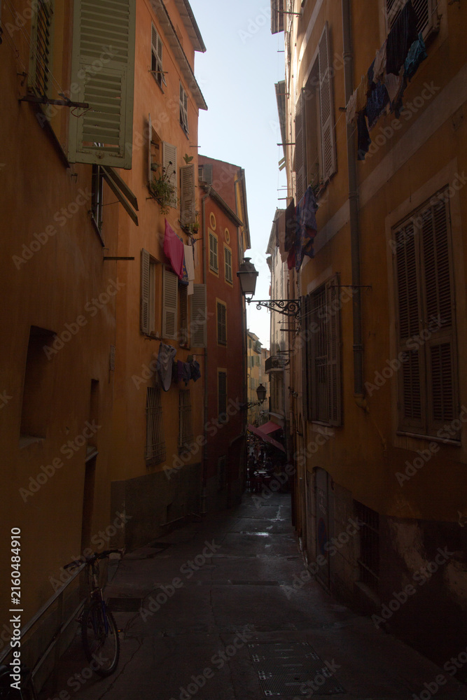 Fototapeta premium Narrow old town street with ochre facades, Nice, France