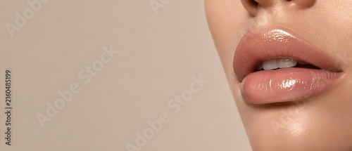 Macro close up of beautiful female lips with glossy nude lip gloss and perfect white teeth smile, premium cosmetics makeup and luxury beauty branding concept with large copy space