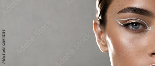 Macro close up of beautiful female eye with metallic silver graphic eyeliner makeup and laminated eyebrow, premium cosmetics and futuristic cyberpunk beauty branding concept with large copy space