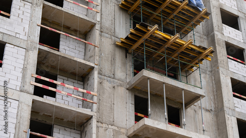Obraz na plátně Unfinished residential building with concrete structure and temporary formwork, showing the process of urban development, construction and modern architecture