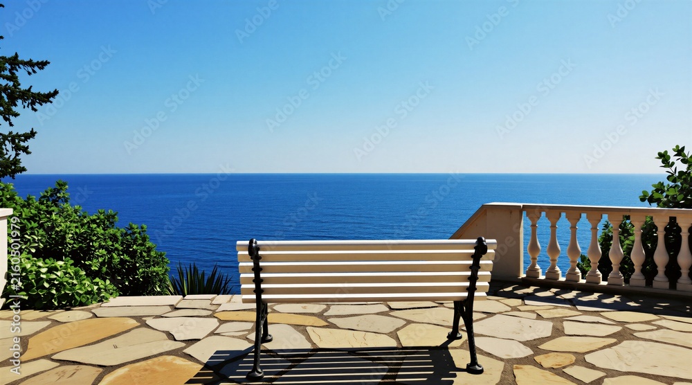 Fototapeta premium Empty bench overlooks deep blue sea and clear sky from paved terrace. Rich green bushes and white balustrade frame tranquil ocean view. Sunny day evokes peaceful vacation mood.